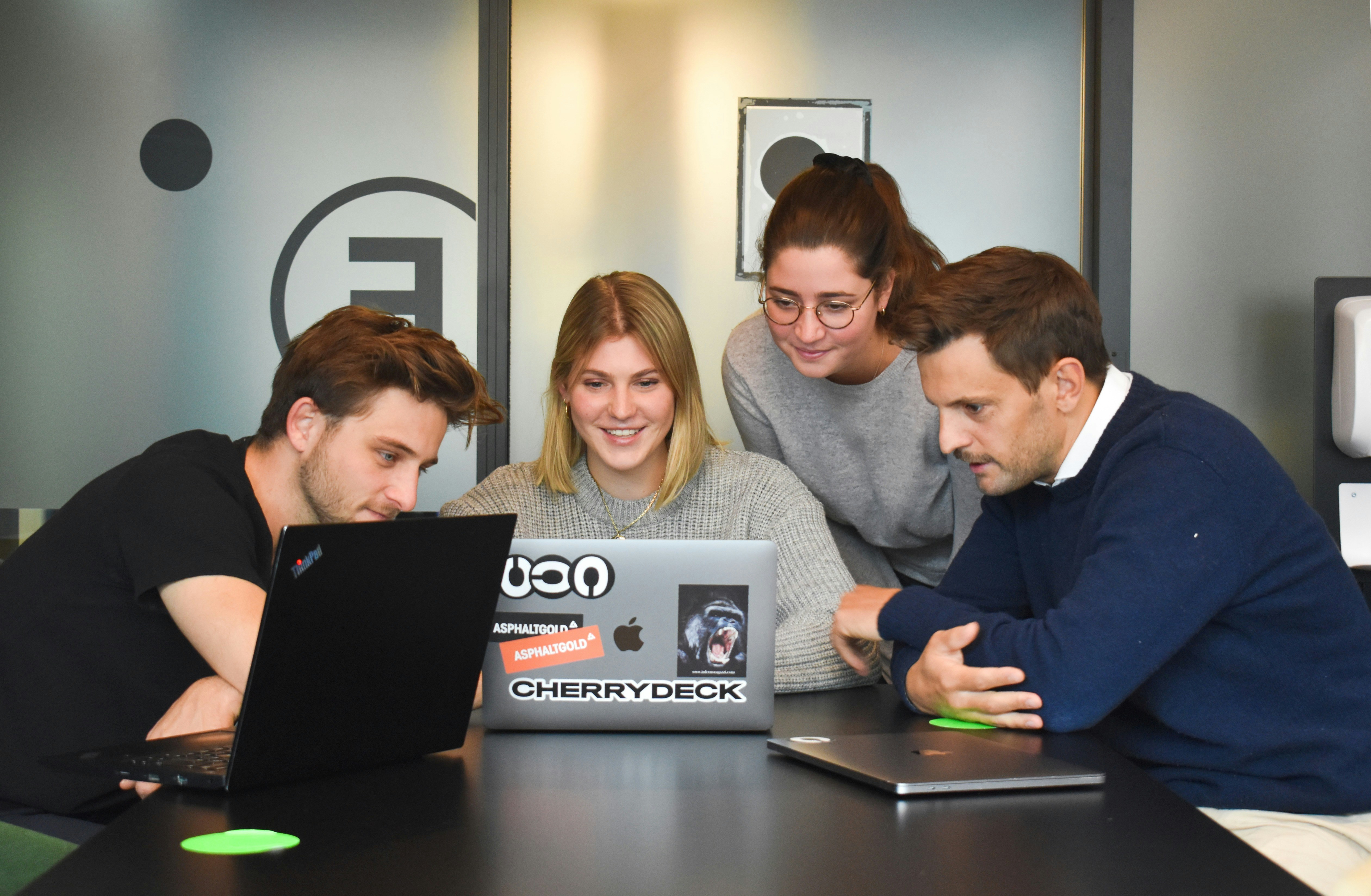 Dev and IT team collaborating around a laptop